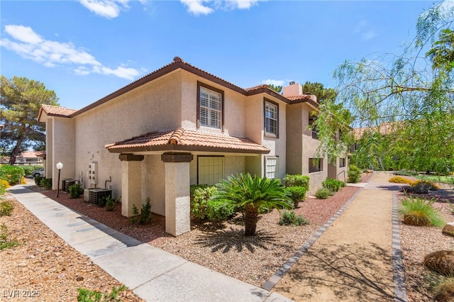 2606 S Durango Dr Unit 245, Las Vegas, NV 89117 - view of front of property with stucco siding, a tile roof, a chimney, and central AC unit