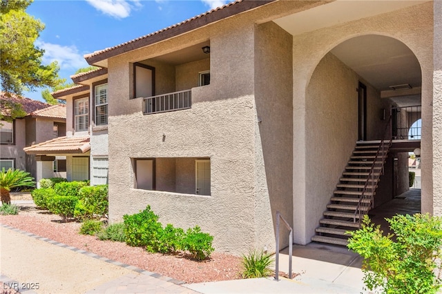 2606 S Durango Dr Unit 245, Las Vegas, NV 89117 - view of side of home with stucco siding, stairs, and a tile roof