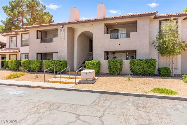 2606 S Durango Dr Unit 245, Las Vegas, NV 89117 - view of front of home with a chimney, stairs, stucco siding, and a tiled roof