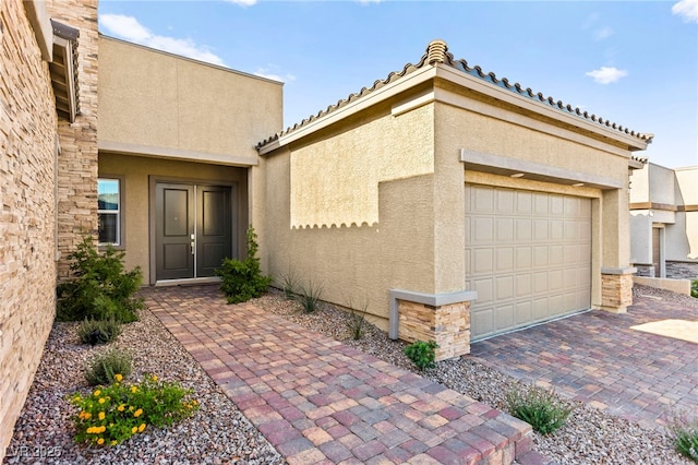 10906 Mila Landing Ave, Las Vegas, NV 89166 - doorway to property featuring stucco siding, a garage, decorative driveway, and a tile roof