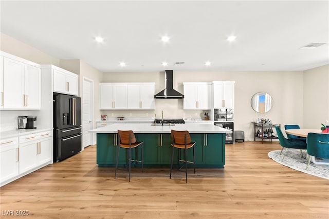 10906 Mila Landing Ave, Las Vegas, NV 89166 - kitchen with wall chimney exhaust hood, black fridge with ice dispenser, light countertops, a breakfast bar area, and a kitchen island with sink
