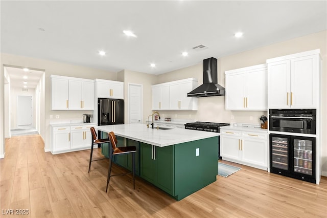10906 Mila Landing Ave, Las Vegas, NV 89166 - kitchen with wall chimney range hood, beverage cooler, a sink, an island with sink, and white cabinetry