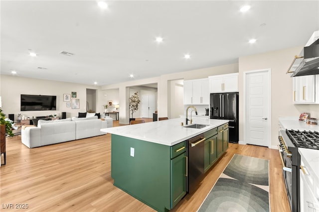 10906 Mila Landing Ave, Las Vegas, NV 89166 - kitchen with green cabinetry, a sink, appliances with stainless steel finishes, white cabinets, and light wood finished floors