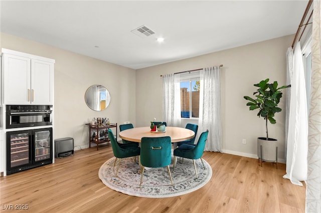 10906 Mila Landing Ave, Las Vegas, NV 89166 - dining space featuring wine cooler, light wood-style flooring, and baseboards
