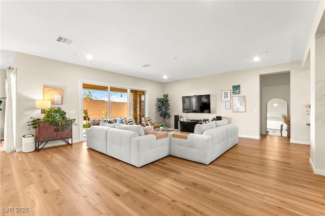 10906 Mila Landing Ave, Las Vegas, NV 89166 - living room with light wood-style flooring, arched walkways, recessed lighting, and baseboards