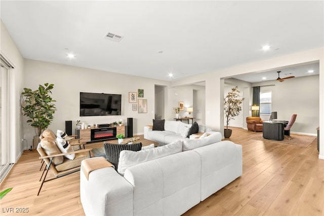 10906 Mila Landing Ave, Las Vegas, NV 89166 - living area featuring light wood finished floors, recessed lighting, a glass covered fireplace, and ceiling fan