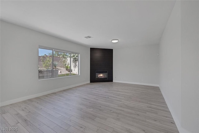 10113 Plomosa Pl, Las Vegas, NV 89134 - unfurnished living room featuring light wood-style floors, a large fireplace, and baseboards