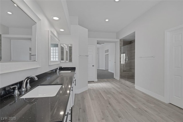 10113 Plomosa Pl, Las Vegas, NV 89134 - bathroom featuring recessed lighting, baseboards, double vanity, a stall shower, and wood finished floors