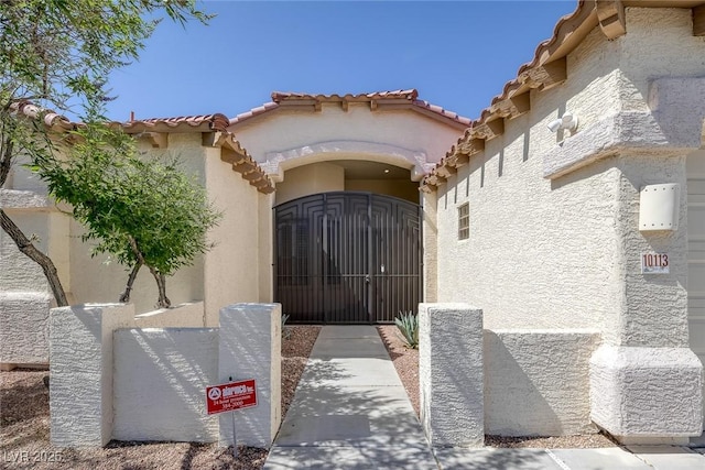 10113 Plomosa Pl, Las Vegas, NV 89134 - doorway to property with stucco siding, a gate, and a tiled roof