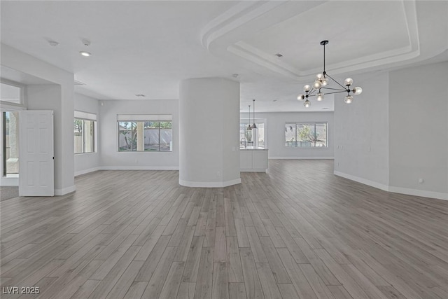 10113 Plomosa Pl, Las Vegas, NV 89134 - unfurnished living room featuring a chandelier, wood finished floors, baseboards, a tray ceiling, and recessed lighting