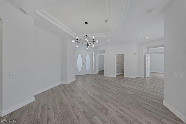 10113 Plomosa Pl, Las Vegas, NV 89134 - unfurnished living room with a raised ceiling, a chandelier, baseboards, light wood-style floors, and recessed lighting