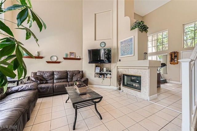 1116 Avellino Ln, Las Vegas, NV 89144 - living room featuring a towering ceiling, light tile patterned flooring, a tiled fireplace, and baseboards