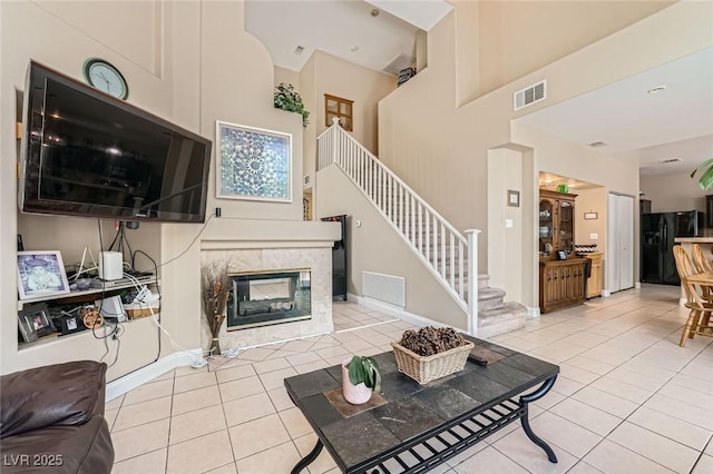 1116 Avellino Ln, Las Vegas, NV 89144 - tiled living room featuring stairs, a high ceiling, and a tile fireplace