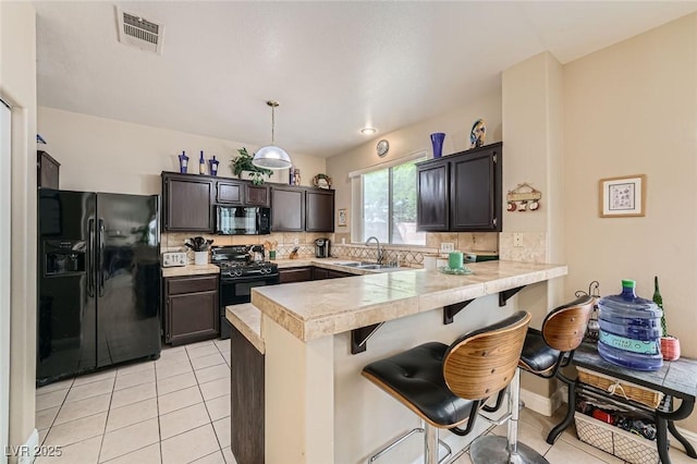 1116 Avellino Ln, Las Vegas, NV 89144 - kitchen featuring black appliances, a peninsula, a breakfast bar area, tasteful backsplash, and a sink