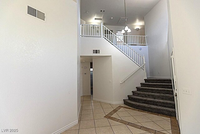 1721 Mill Canyon Dr, Las Vegas, NV 89128 - stairs featuring tile patterned floors, baseboards, a chandelier, and a towering ceiling