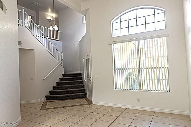 1721 Mill Canyon Dr, Las Vegas, NV 89128 - entrance foyer with a chandelier, stairway, a towering ceiling, tile patterned flooring, and baseboards