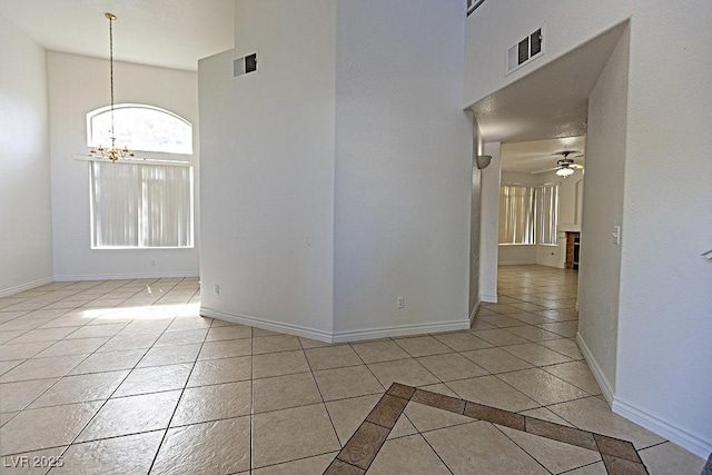 1721 Mill Canyon Dr, Las Vegas, NV 89128 - spare room featuring a high ceiling, a chandelier, ceiling fan, baseboards, and light tile patterned floors