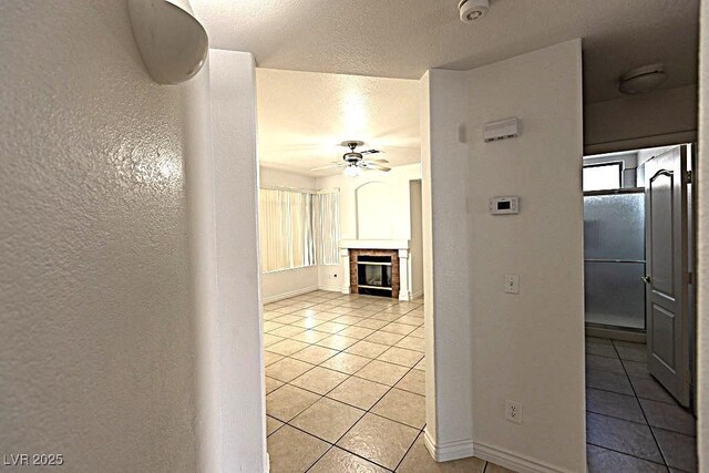 1721 Mill Canyon Dr, Las Vegas, NV 89128 - hallway with light tile patterned flooring, a textured wall, baseboards, and a textured ceiling