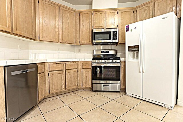 1721 Mill Canyon Dr, Las Vegas, NV 89128 - kitchen featuring appliances with stainless steel finishes, tile countertops, and light tile patterned floors