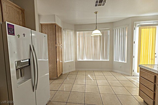1721 Mill Canyon Dr, Las Vegas, NV 89128 - kitchen featuring white fridge with ice dispenser, tile countertops, baseboards, and light tile patterned floors
