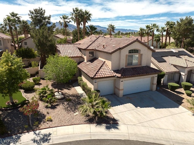 1721 Mill Canyon Dr, Las Vegas, NV 89128 - mediterranean / spanish-style home featuring stucco siding, a tile roof, concrete driveway, a garage, and a mountain view