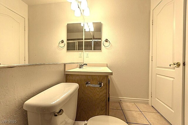1721 Mill Canyon Dr, Las Vegas, NV 89128 - half bath with tile patterned flooring, toilet, vanity, baseboards, and a textured wall