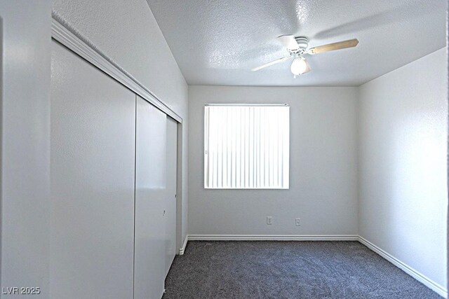 1721 Mill Canyon Dr, Las Vegas, NV 89128 - unfurnished bedroom with dark carpet, baseboards, a closet, and a textured ceiling