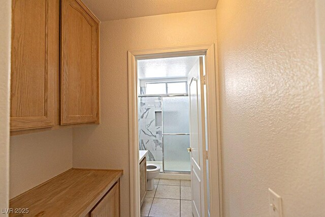 1721 Mill Canyon Dr, Las Vegas, NV 89128 - full bathroom featuring toilet, a shower stall, a textured wall, and tile patterned flooring