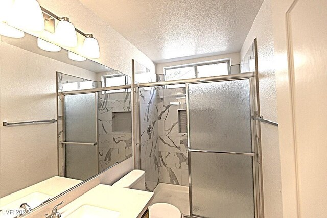 1721 Mill Canyon Dr, Las Vegas, NV 89128 - full bathroom featuring a textured wall, a textured ceiling, a stall shower, vanity, and toilet