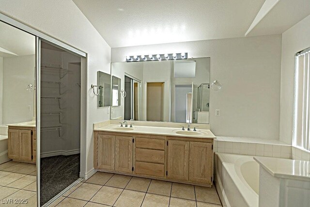 1721 Mill Canyon Dr, Las Vegas, NV 89128 - bathroom featuring tile patterned flooring, double vanity, a bath, a walk in closet, and a shower stall