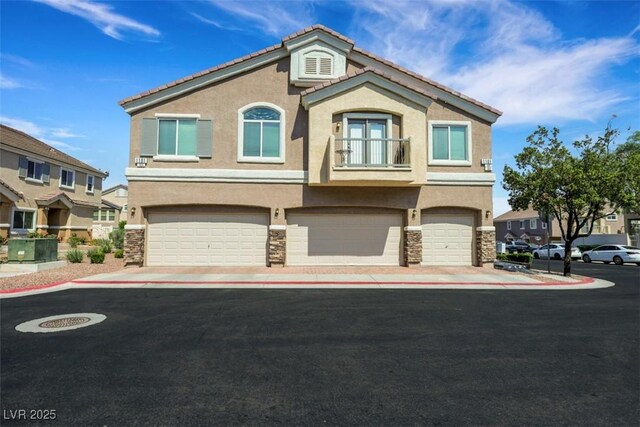 1101 Elation Ln Unit 2, Henderson, NV 89002 - townhome / multi-family property with stucco siding, stone siding, an attached garage, and a balcony