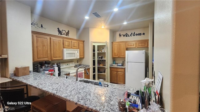 864 Chianti Way, Mesquite, NV 89027 - kitchen with white appliances, a peninsula, a sink, and light stone counters