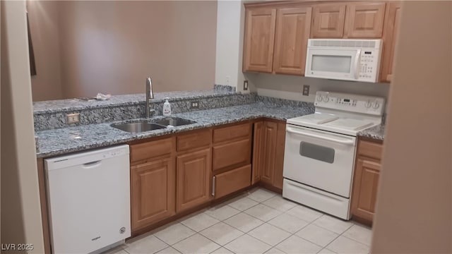 864 Chianti Way, Mesquite, NV 89027 - kitchen with white appliances, a sink, stone counters, light tile patterned flooring, and brown cabinets
