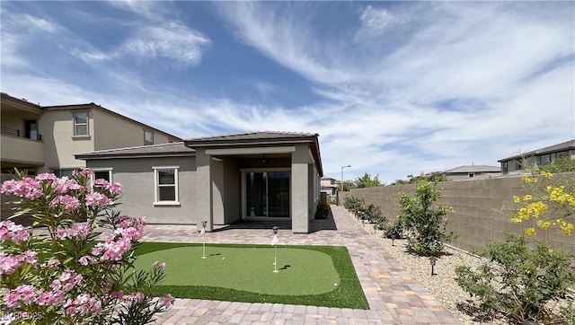 12565 Huckleberry Oak Ave, Las Vegas, NV 89138 - rear view of property featuring an area to practice putting, stucco siding, and a patio
