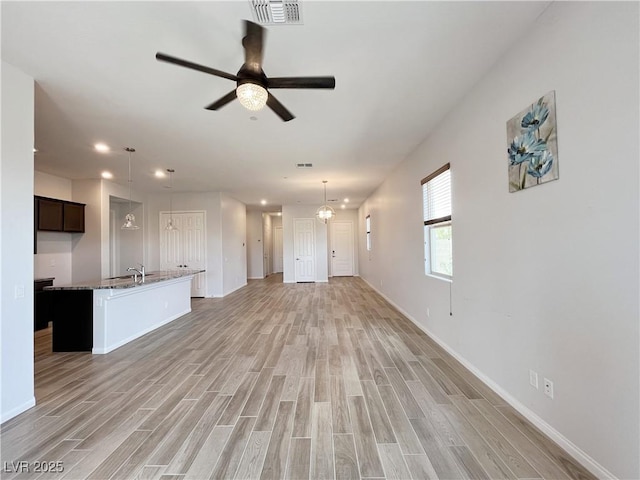 12565 Huckleberry Oak Ave, Las Vegas, NV 89138 - unfurnished living room featuring light wood-style floors, a ceiling fan, baseboards, a sink, and recessed lighting