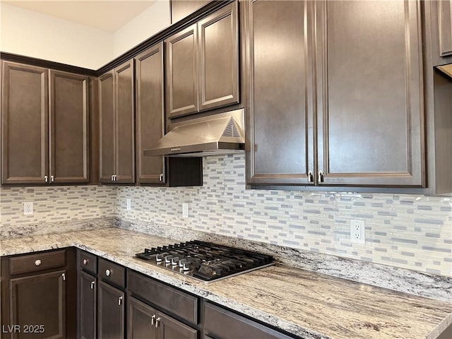 12565 Huckleberry Oak Ave, Las Vegas, NV 89138 - kitchen with under cabinet range hood, stainless steel gas stovetop, dark brown cabinets, and backsplash