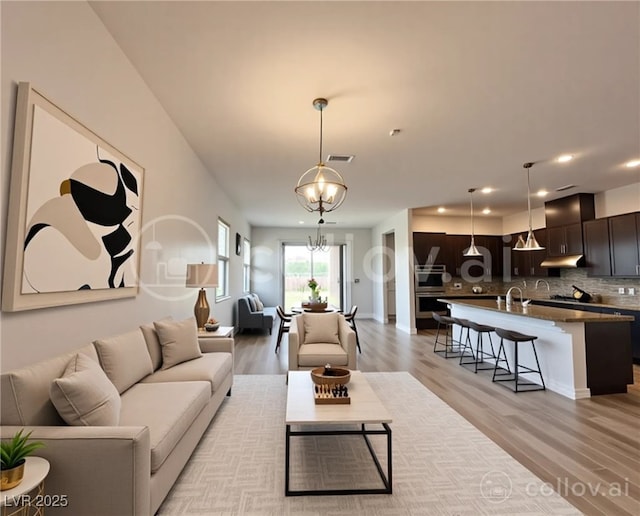 12565 Huckleberry Oak Ave, Las Vegas, NV 89138 - living area featuring a chandelier, light wood-style floors, recessed lighting, and baseboards
