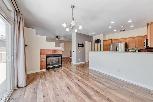 4044 Villeroy Ave, Las Vegas, NV 89141 - unfurnished living room with a chandelier, light wood-type flooring, ceiling fan, a fireplace, and recessed lighting