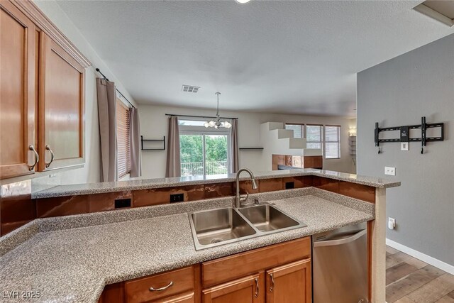 4044 Villeroy Ave, Las Vegas, NV 89141 - kitchen with stainless steel dishwasher, a sink, light wood-style flooring, and brown cabinets