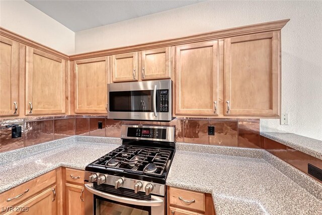 4044 Villeroy Ave, Las Vegas, NV 89141 - kitchen with appliances with stainless steel finishes, backsplash, and light stone counters
