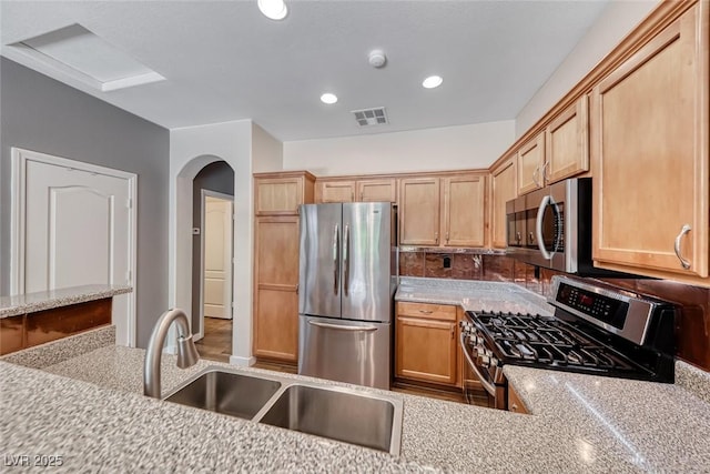 4044 Villeroy Ave, Las Vegas, NV 89141 - kitchen featuring stainless steel appliances, recessed lighting, a sink, light brown cabinetry, and arched walkways