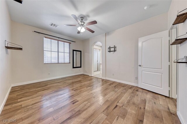 4044 Villeroy Ave, Las Vegas, NV 89141 - unfurnished room with a ceiling fan, arched walkways, light wood finished floors, and baseboards