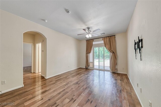 4044 Villeroy Ave, Las Vegas, NV 89141 - spare room featuring a ceiling fan, arched walkways, wood finished floors, a smoke detector, and baseboards