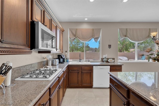 9017 Cotton Rose Way, Las Vegas, NV 89134 - kitchen with white appliances, a sink, recessed lighting, brown cabinets, and light tile patterned floors