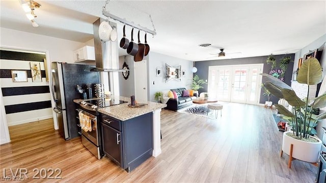 5817 Rae Dr, Las Vegas, NV 89108 - kitchen with stainless steel appliances, ceiling fan, light wood-type flooring, open floor plan, and light stone countertops