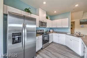 7915 Pandora Sky St Unit 402, North Las Vegas, NV 89084 - kitchen with stainless steel appliances, white cabinetry, wood finished floors, recessed lighting, and a sink