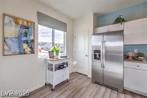 7915 Pandora Sky St Unit 402, North Las Vegas, NV 89084 - kitchen with stainless steel refrigerator with ice dispenser, light wood-style flooring, and white cabinets