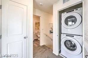 7915 Pandora Sky St Unit 402, North Las Vegas, NV 89084 - washroom with stacked washer and clothes dryer and carpet flooring