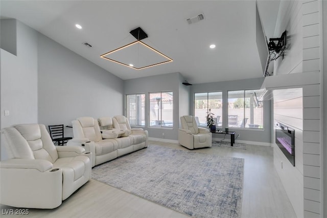 8150 Beaverbrook Way, Las Vegas, NV 89123 - living area featuring wood finished floors, washer / clothes dryer, baseboards, a glass covered fireplace, and recessed lighting