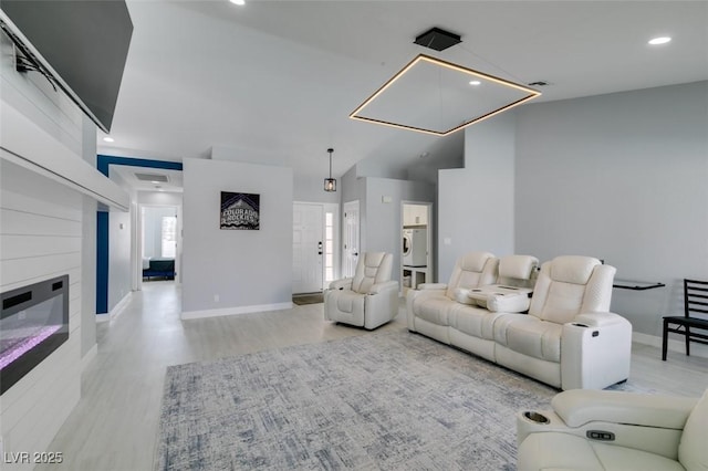 8150 Beaverbrook Way, Las Vegas, NV 89123 - living area featuring wood finished floors, washer / clothes dryer, baseboards, a glass covered fireplace, and recessed lighting